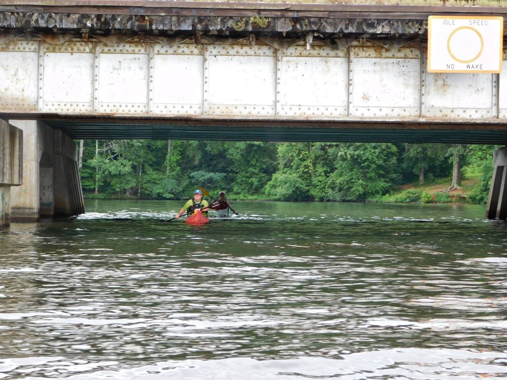 kayaks under bridge