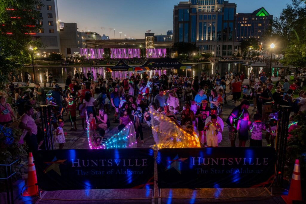 Lights at night in Big Spring Park with the community gathering