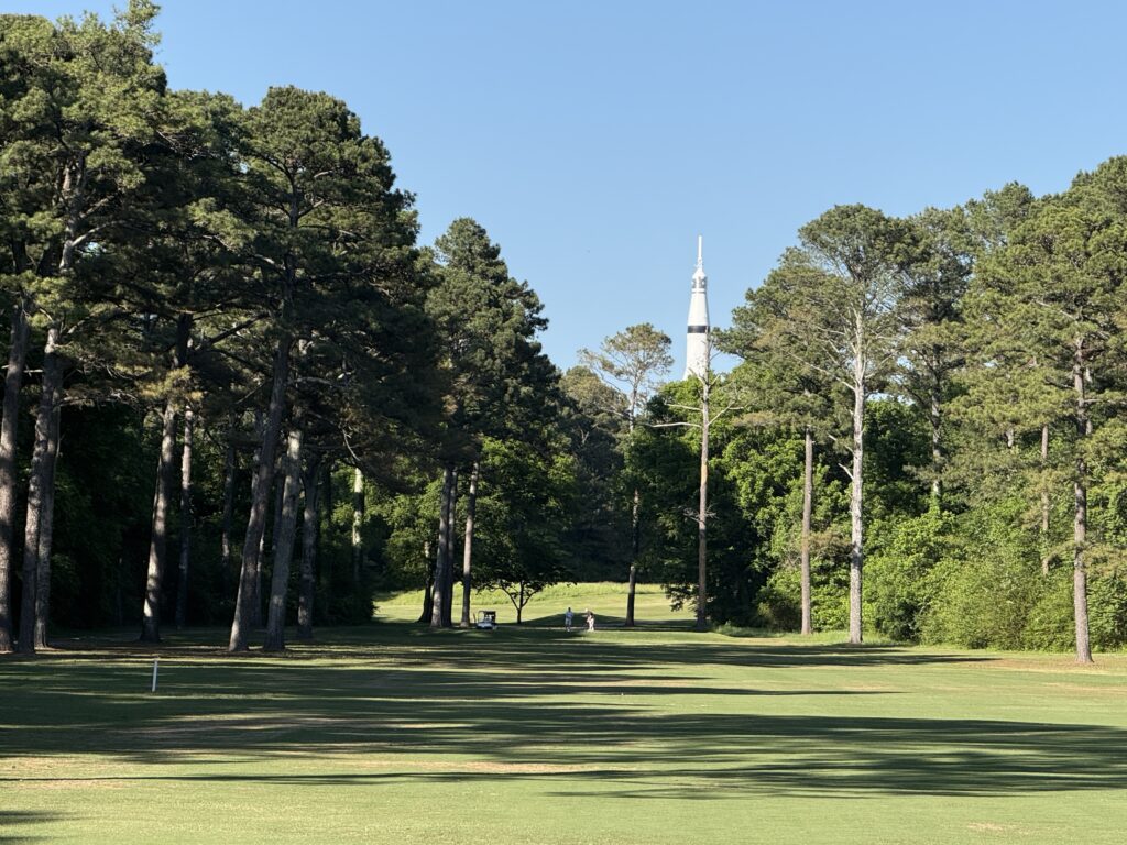 golf course with Saturn V in the background