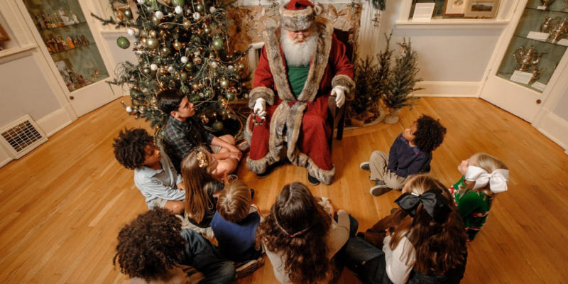 Santa talking to children who are sitting around him in a circle