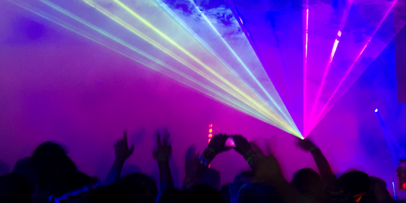 people dancing with a laser light show